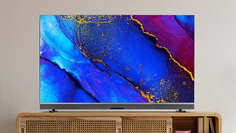 Ein moderner Fernseher auf einer Holzkonsole, der ein lebendiges abstraktes Bild in den Farben Blau, Rot und Gold anzeigt.