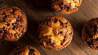 Knusprige Hähnchenflügel mit Glasur und Frühlingszwiebeln auf Teller – zubereitet in der MEDION Heißluftfritteuse.