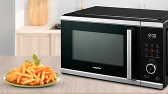 Eine MEDION-Mikrowelle mit digitalem Display steht neben einem Teller mit frisch zubereiteten Pommes.