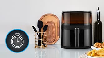 Küchenarbeitsplatte mit Heißluftfritteuse, Besteckhalter, Holztablett und Olivenölflasche. Links ist ein Stoppuhr-Symbol zu sehen.