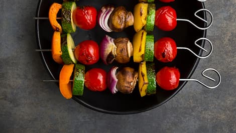 Knusprige Hähnchenflügel mit Glasur und Frühlingszwiebeln auf Teller – zubereitet in der MEDION Heißluftfritteuse.