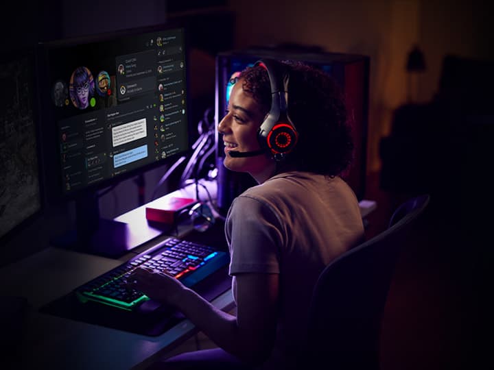 Person beim Gaming am PC mit Headset und RGB-Tastatur
