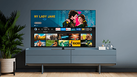 Smart TV auf einer mittelhohen TV Kommode, im Display wird das Menü für Streaminganbieter gezeigt