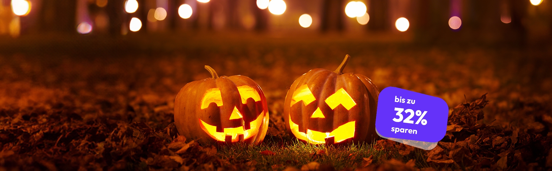 Zwei leuchtende Halloween-Kürbisse auf einer mit Herbstlaub bedeckten Wiese bei Nacht. Violettes Label „bis zu 32 % sparen“.