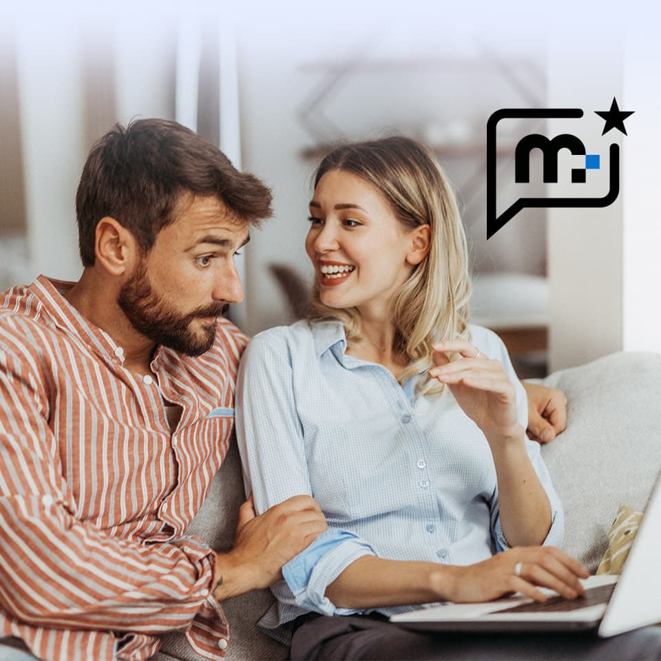 Ein Paar sitzt lächelnd auf einem Sofa und schaut gemeinsam auf einen Laptop. In der oberen rechten Ecke befindet sich ein Sprechblasensymbol mit „m“ Medion Symbol.